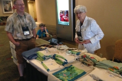 Fay Wagman reviewing the promotional items table with Brad Walker