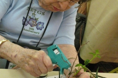 Mary Bozoian using a glue-gun to hold her design in place