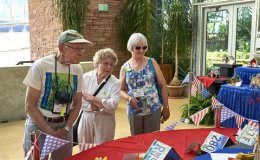 Ben Paternoster, Anne Vidaver, Bonnie Bake enjoying the display of state license plate birdhouses