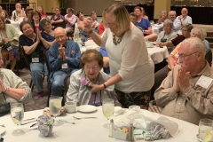 Judy Zinni pinning gesneriad corsage honoring Mary Bozoian